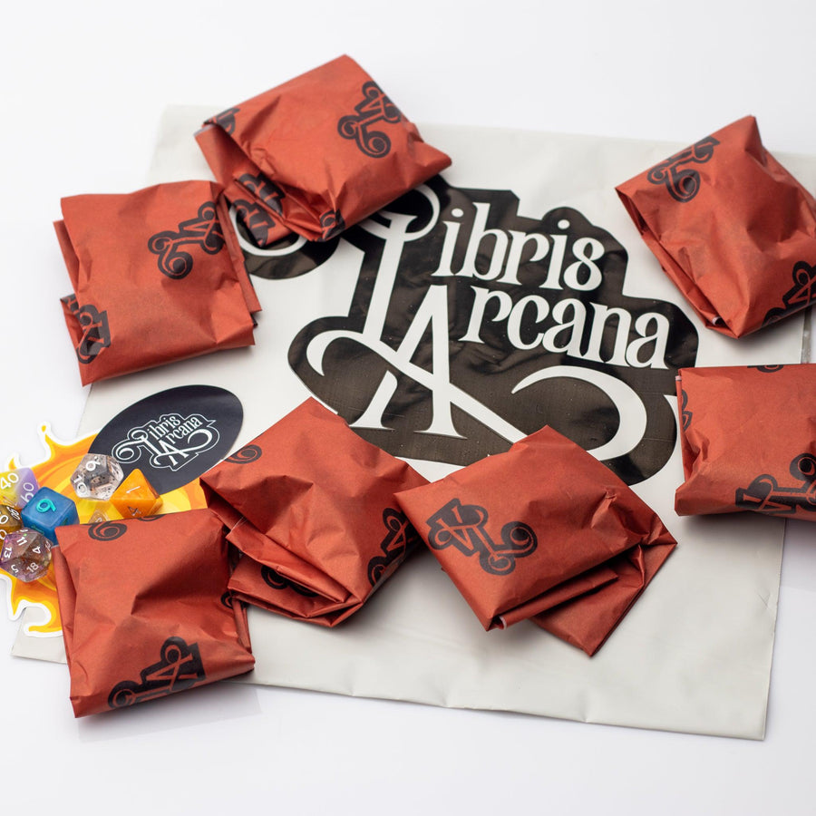 Libris Arcana Dice Addict Subscription, 7 full sets of dice, 7 random dice, and packaging laid out on a white background.