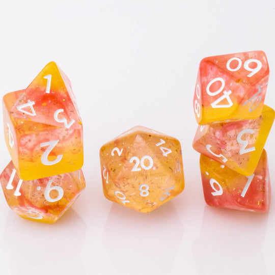 Dreamsicle, rose gold and orange dnd dice set stacked on a white background.