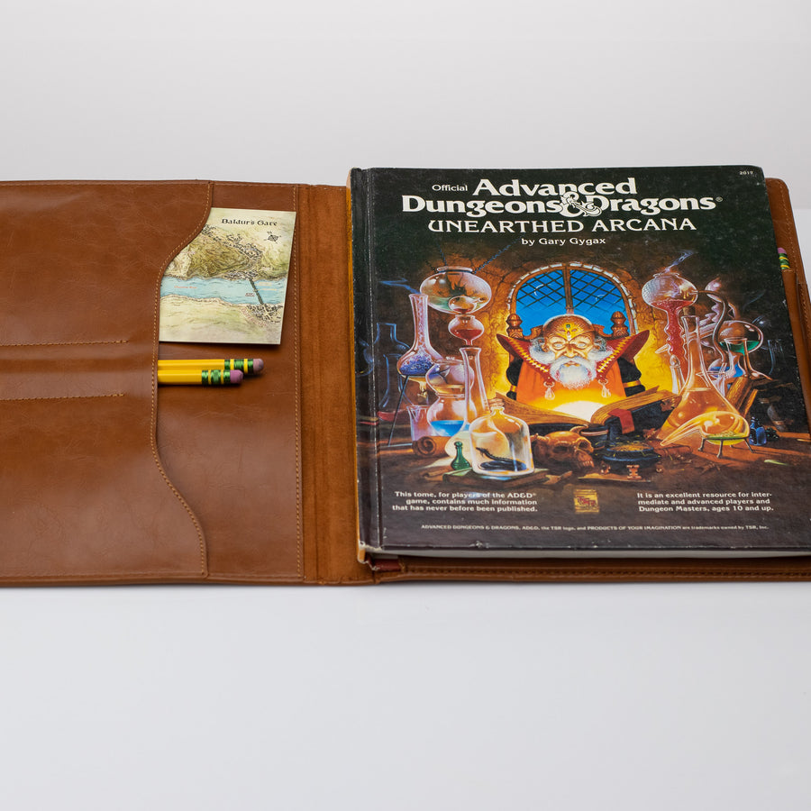 Faux Leather TTRPG book cover in natural brown, open with DND book and supplies.