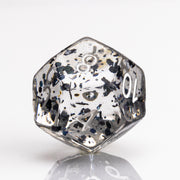 Upside Down, crystal clear 7 piece DND dice set with dark floating inclusions D12 on white background.