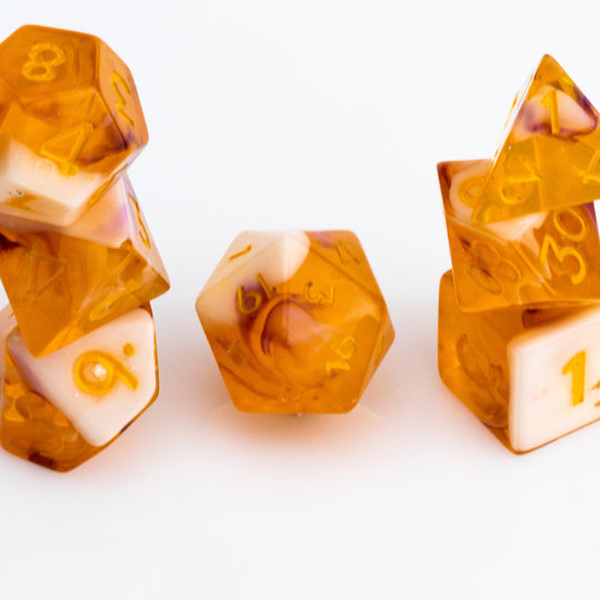 Autumn Spirit, trunslucent orange resin with swriling lavender and opaque cream. 7 piece RPG dice set stacked on white background.