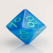 Infinite, cloudy blue dice with glittery inclusions and teal numbering. D00 on white background.