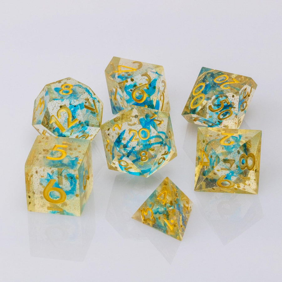 Moonlight, gold and blue handmade RPG dice set on a white background.