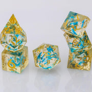 Moonlight, gold and blue handmade RPG dice set stacked on a white background.