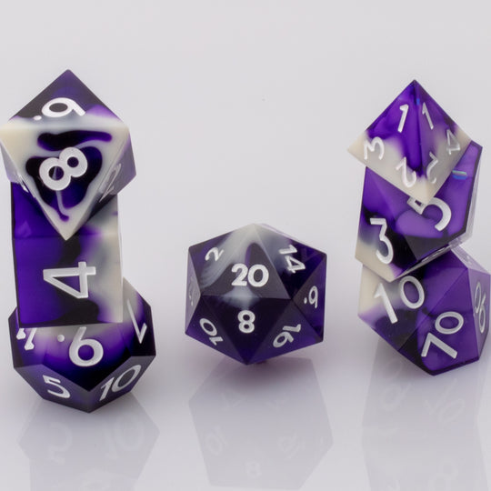 Nightfall, purple and white handmade DND dice set stacked on a white background.