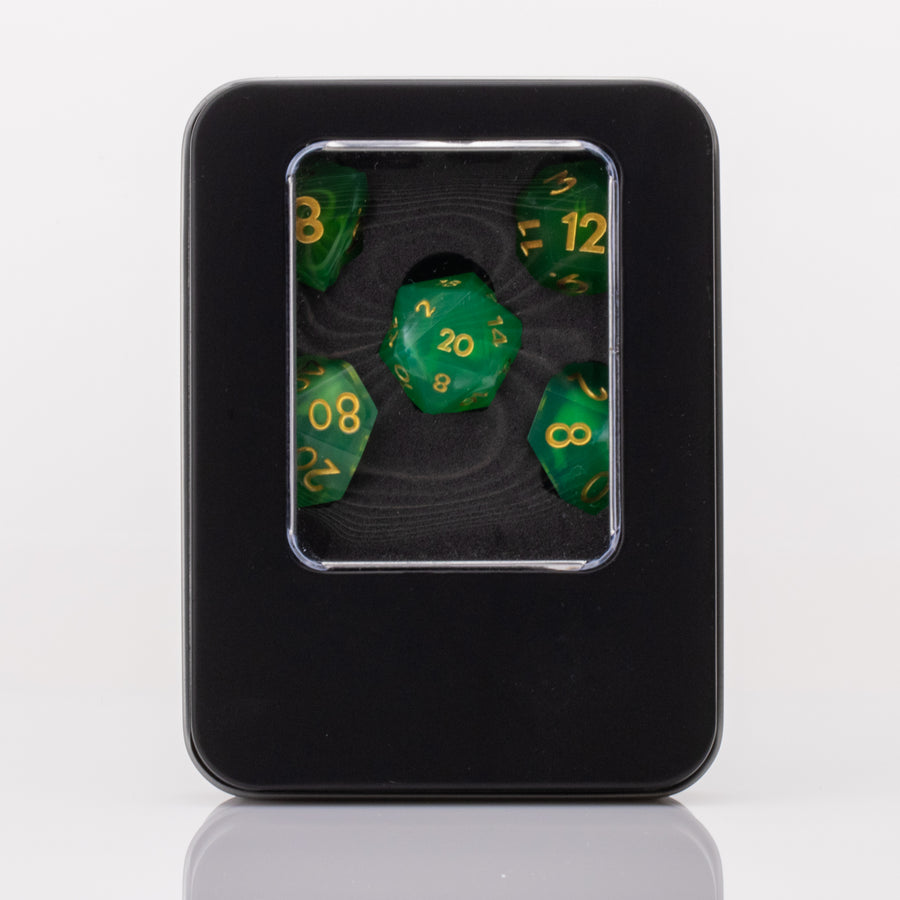 Nirvana, swirling green handmade RPG dice set in decorative tin on a white background.