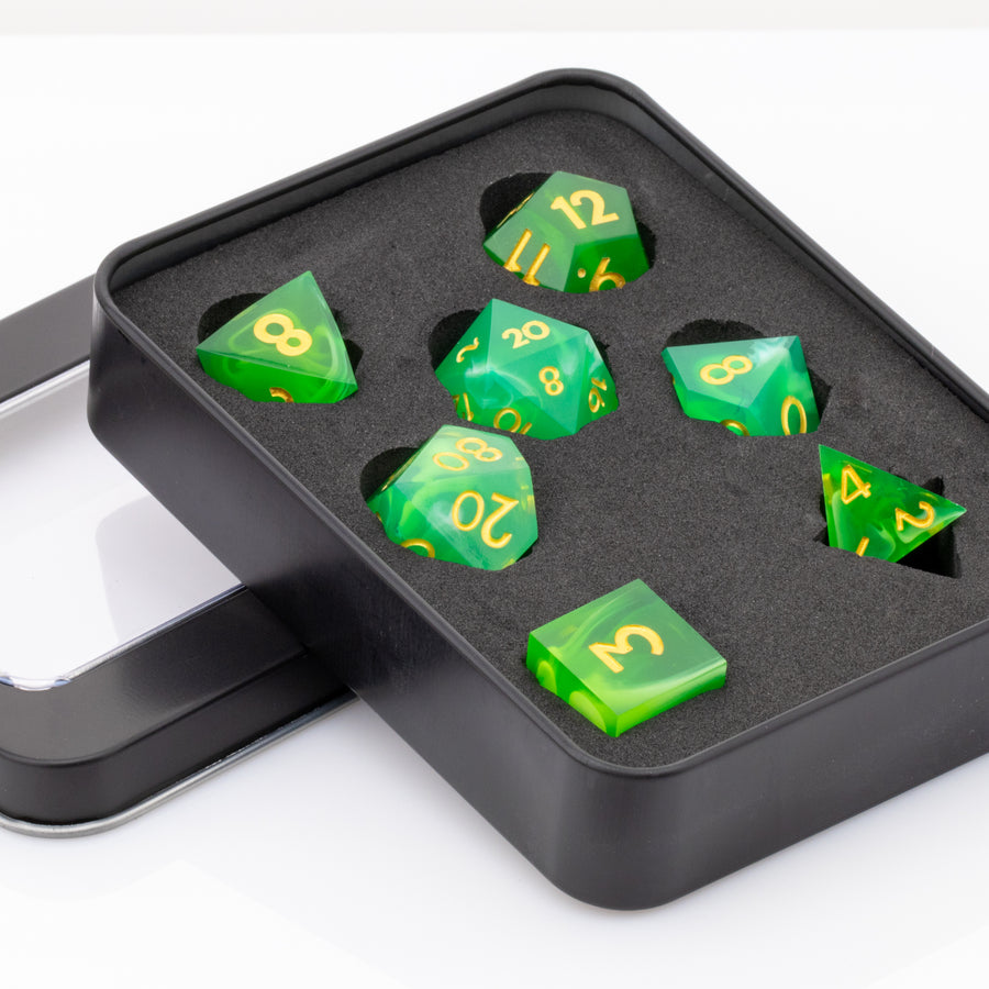 Nirvana, swirling green handmade RPG dice set in decorative tin on a white background.