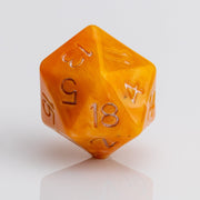 Orcana--Orange swirled RPG dice with gold metallic inking. D20 on white background.