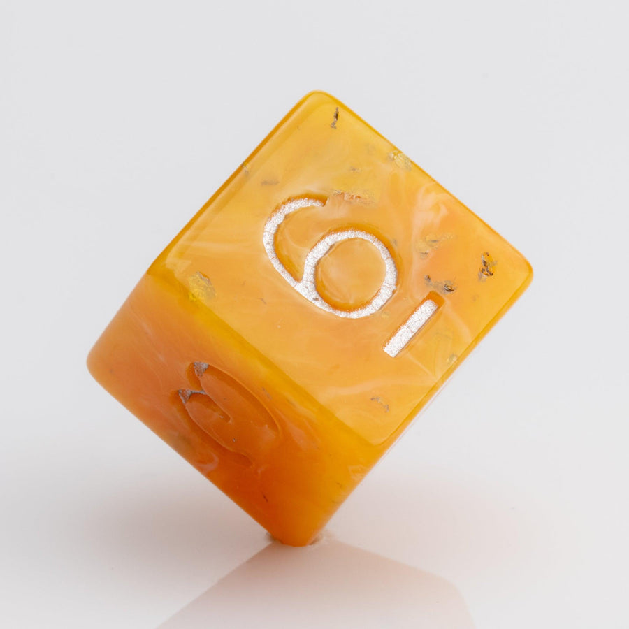Orcana--Orange swirled RPG dice with gold metallic inking. D6 on white background.