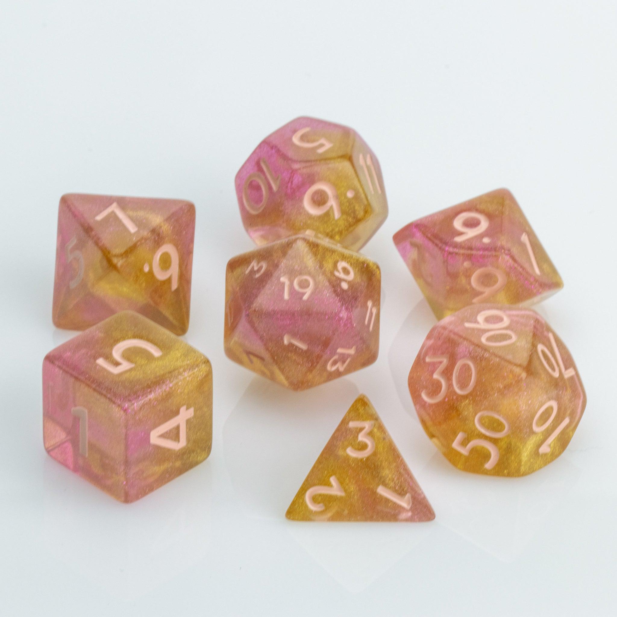 Pamplemousse, pink & orange gold 7 piece RPG dice set on a white background.