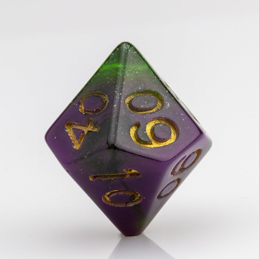 Perseid--Green and purple RPG dice with with swirled, glittery inclusions and gold metallic inking. D00 on white background.