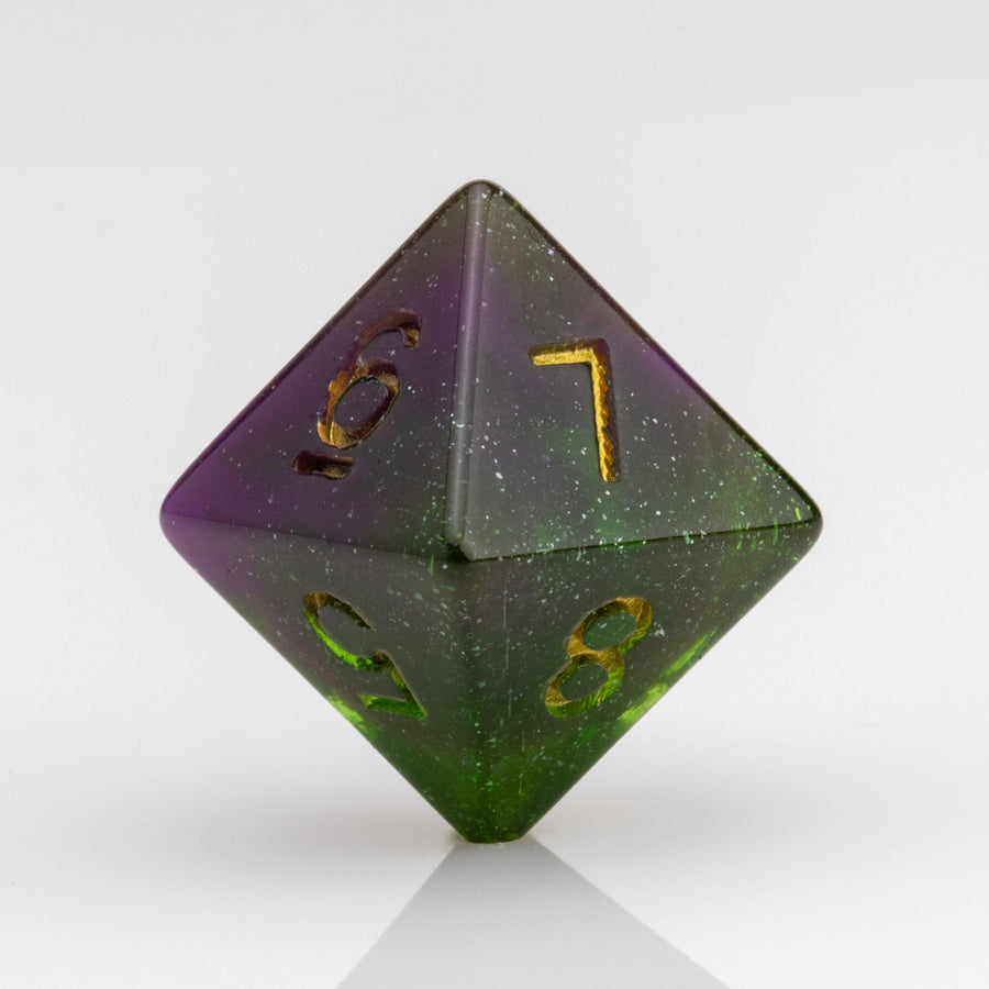 Perseid--Green and purple RPG dice with with swirled, glittery inclusions and gold metallic inking. D8 on white background.