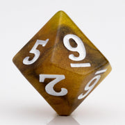 Scorch, yellow, brown and black resin DND dice 7 piece set D10 on white background.
