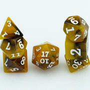 Scorch, yellow, brown and black resin DND dice 7 piece set stacked on white background.