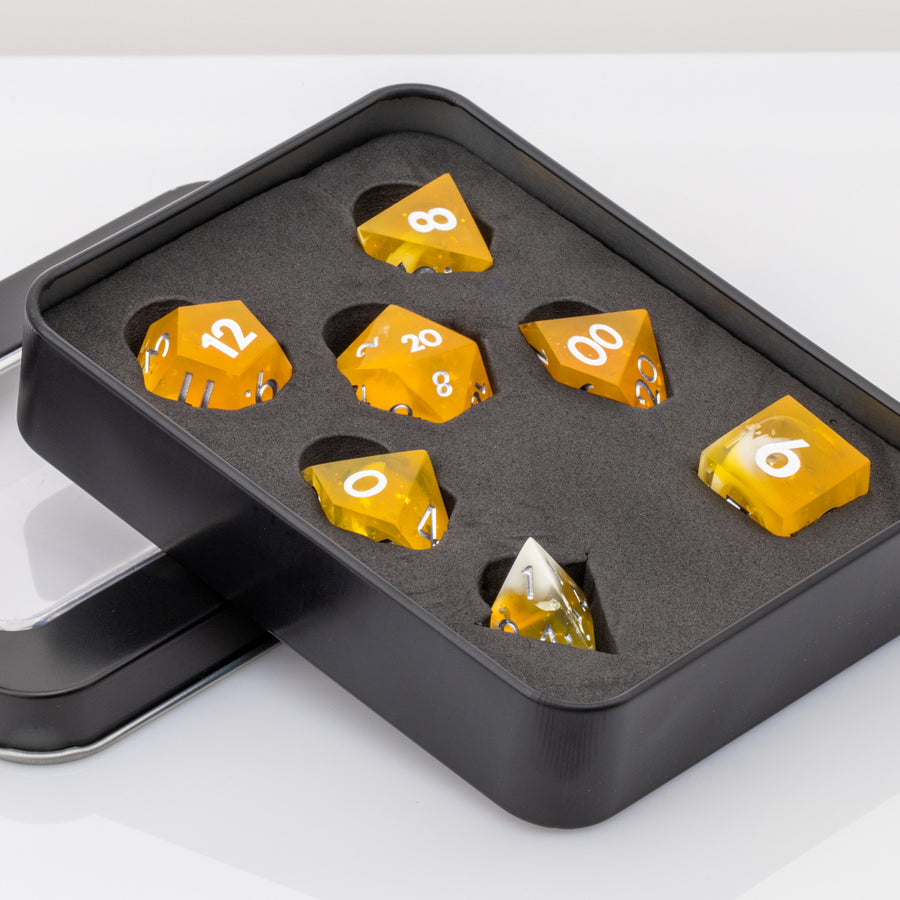 Sundown, swirling orange and white handmade RPG dice set in decorative tin on a white background.