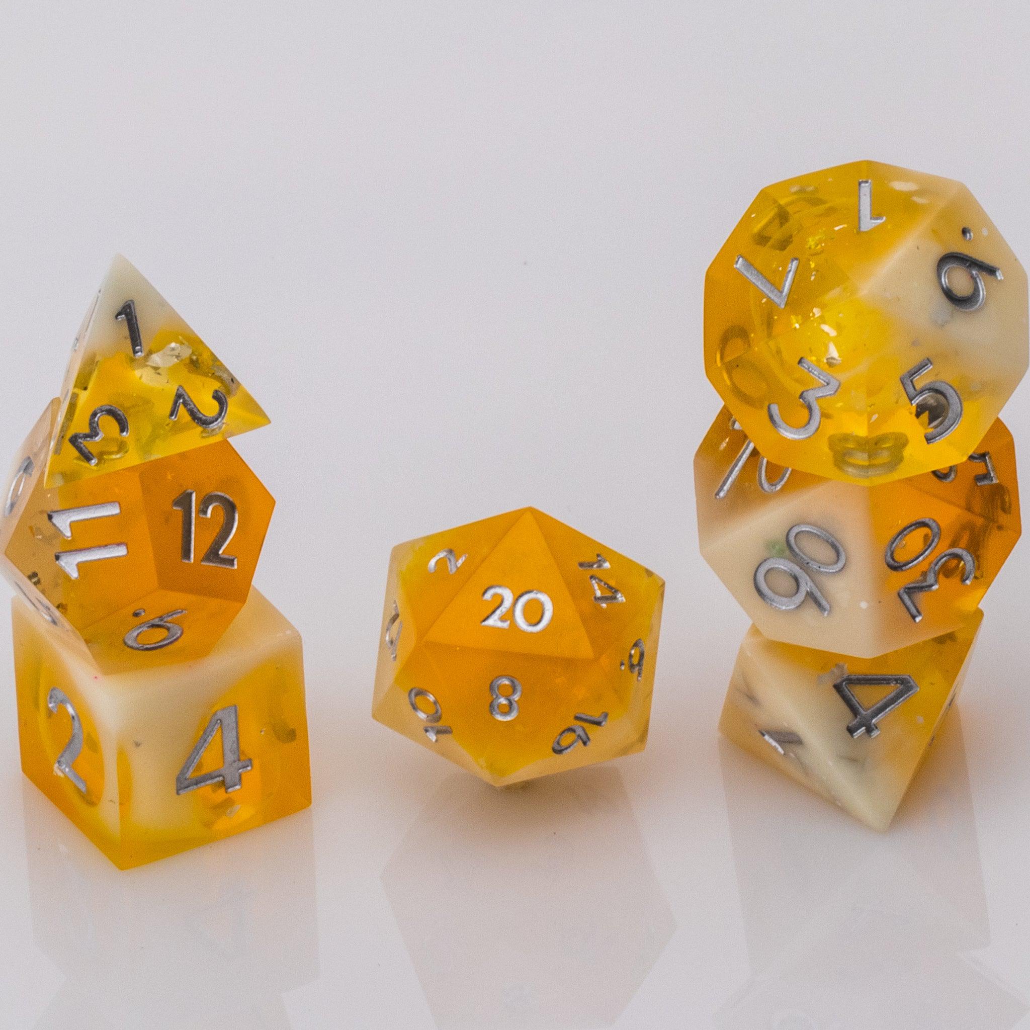 Sundown, swirling orange and white handmade RPG dice set stacked on a white background.