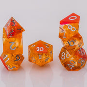 Sunfire, swirling orange and red handmade DND dice set stacked on a white background.